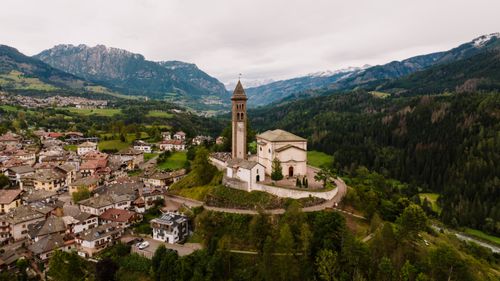 Free Aerial view of a historic church surrounded by mountains in Molveno, Italy. Stock Photo