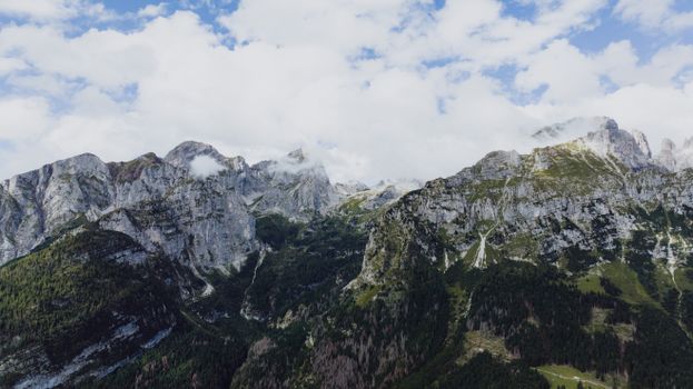 Stunning landscape of Dolomites in Molveno, Italy with lush forests and cloudy skies.