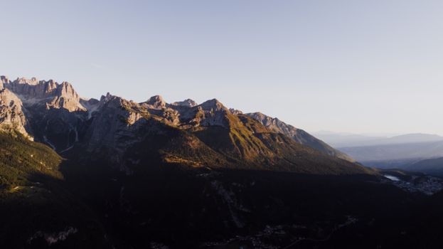 A stunning aerial view of the Molveno mountains bathed in warm dusk light.