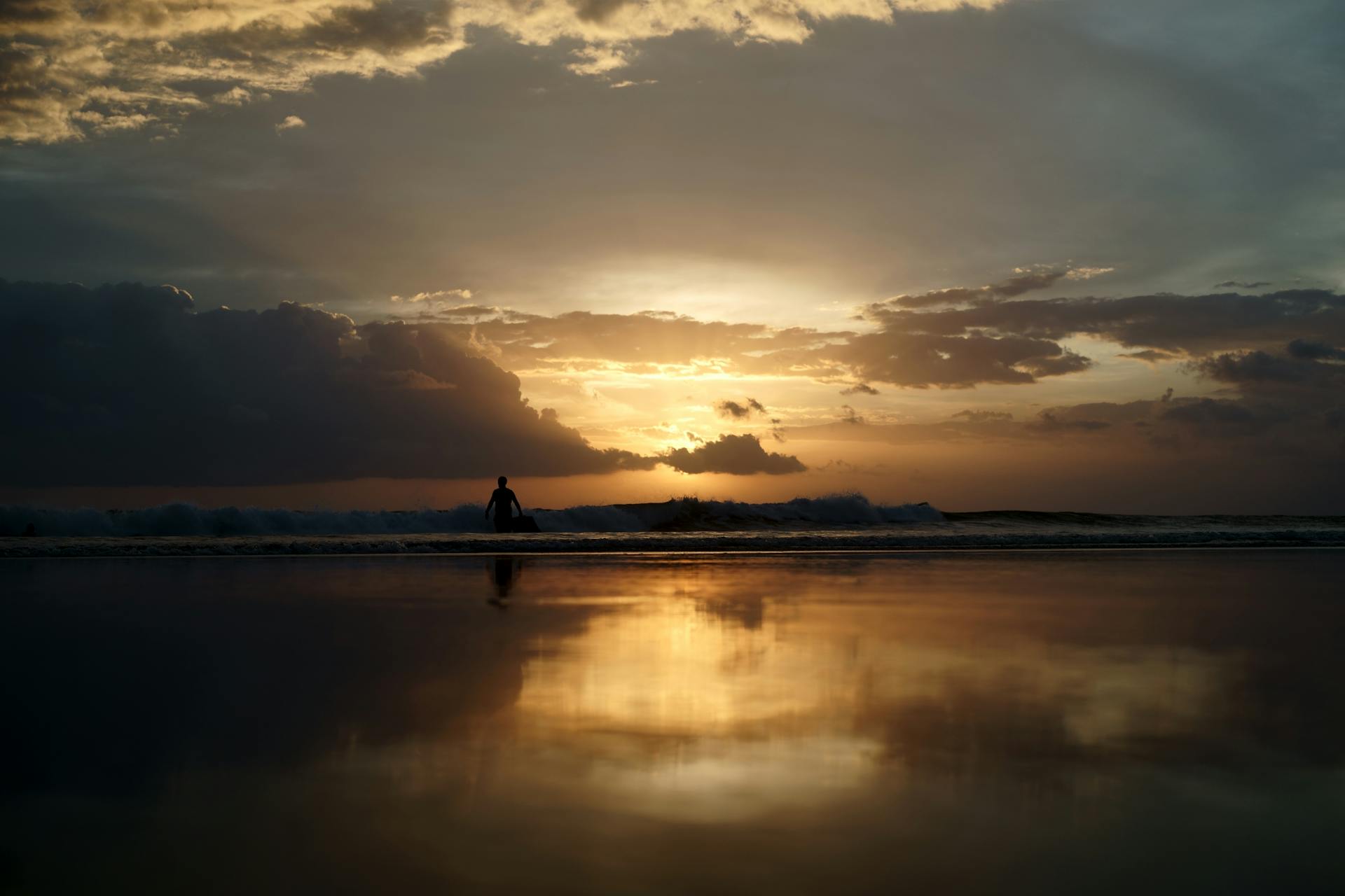 Experience the mesmerizing sunset at Kuta Beach, Bali with reflections on tranquil waters.