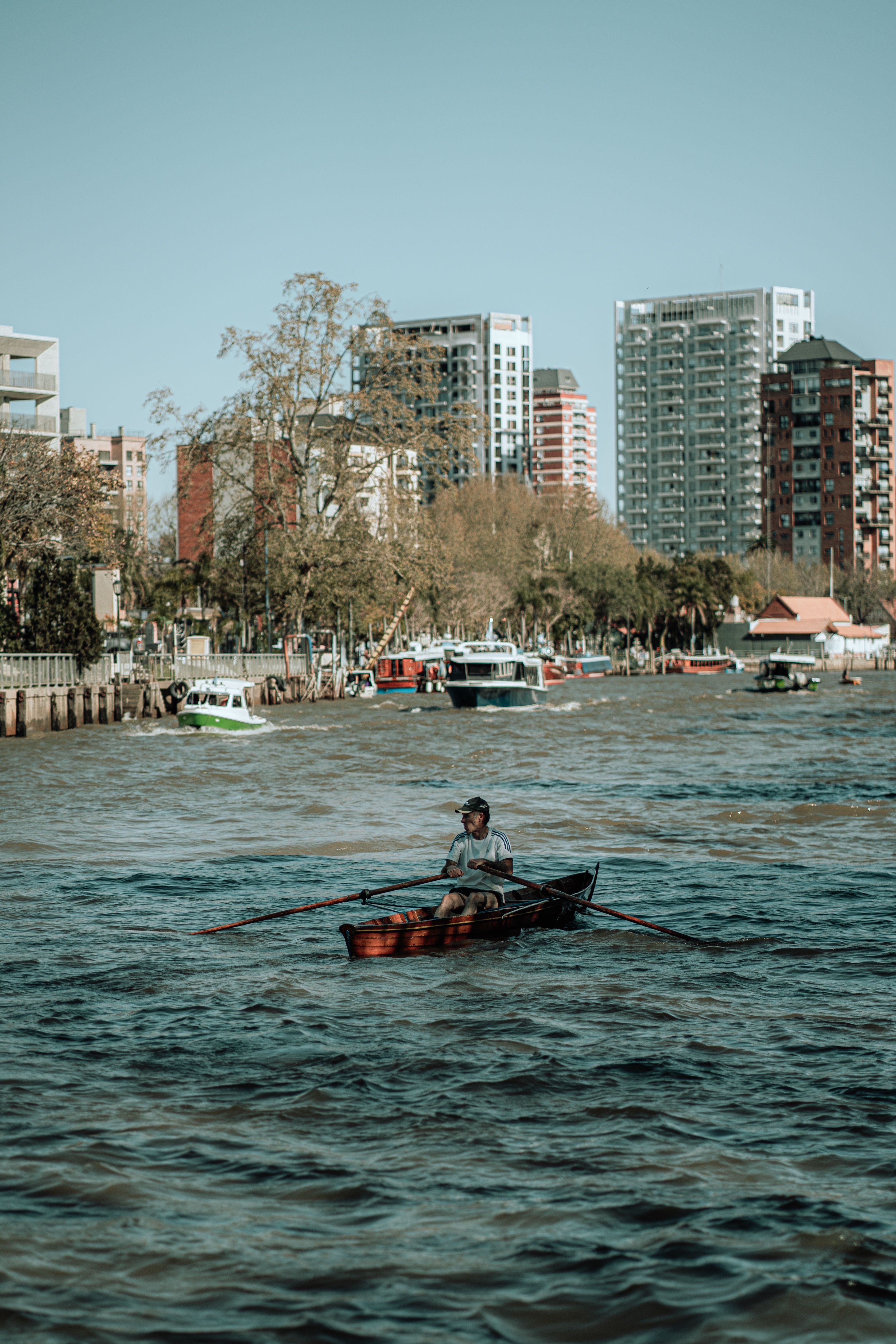 Scenic Urban Waterfront with Rowboat in River · Free Stock Photo