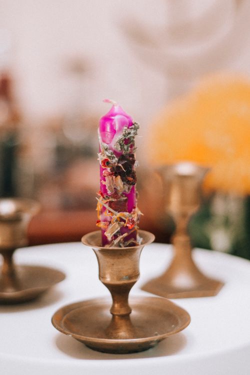 Free A vibrant ornamental candle in a vintage brass holder exudes whimsy and charm. Stock Photo