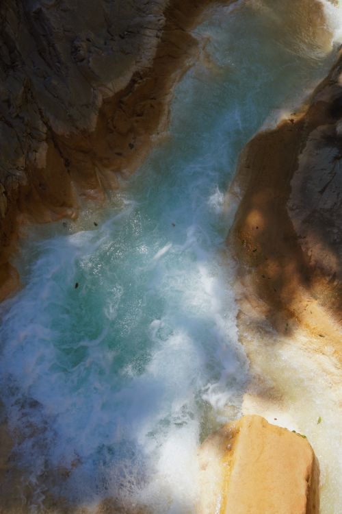 Free A tranquil river stream flowing through a rugged rocky gorge under natural light. Stock Photo