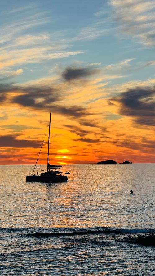 Free A stunning silhouette of a catamaran at sunset on the Ibiza coastline, Spain. Stock Photo
