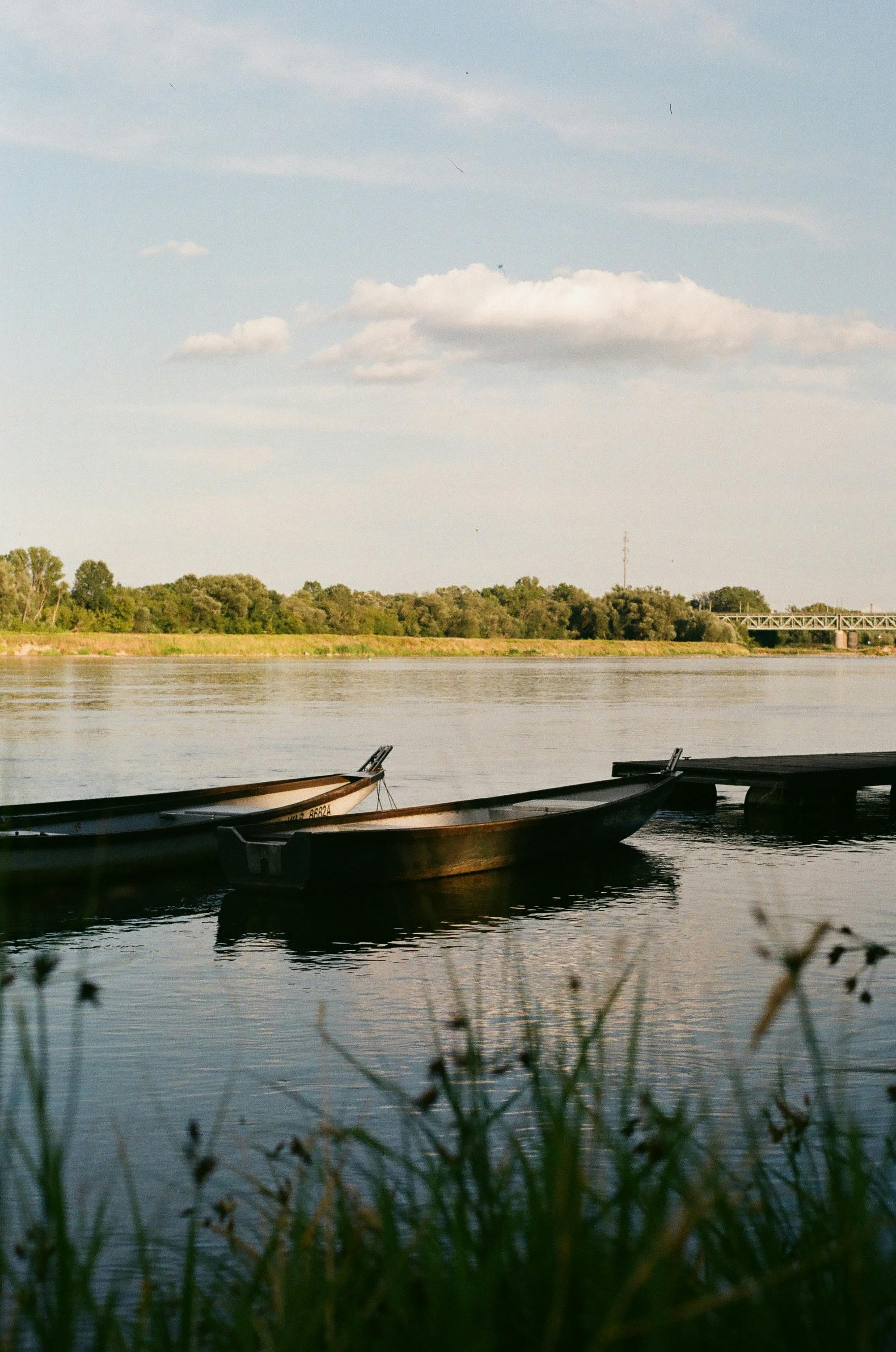 Peaceful scene of boats on the Vistula River in Warsaw during sunset, capturing the tranquil mood.