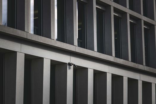 Contemporary office building exterior featuring multiple windows and security cameras.