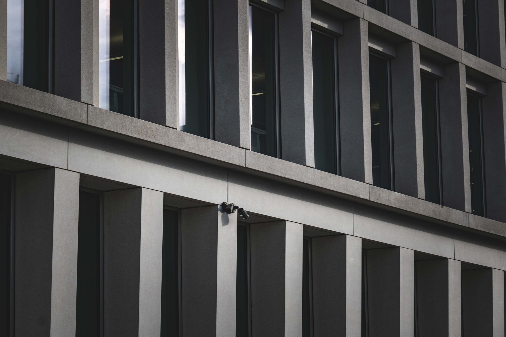 Contemporary office building exterior featuring multiple windows and security cameras.