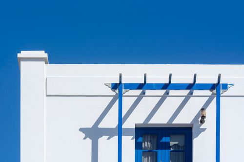 Free A minimalist white facade with blue accents under a clear blue sky in Lanzarote, Spain. Stock Photo