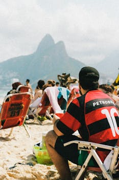 People enjoying sunny Ipanema Beach in Rio de Janeiro with scenic mountain views.