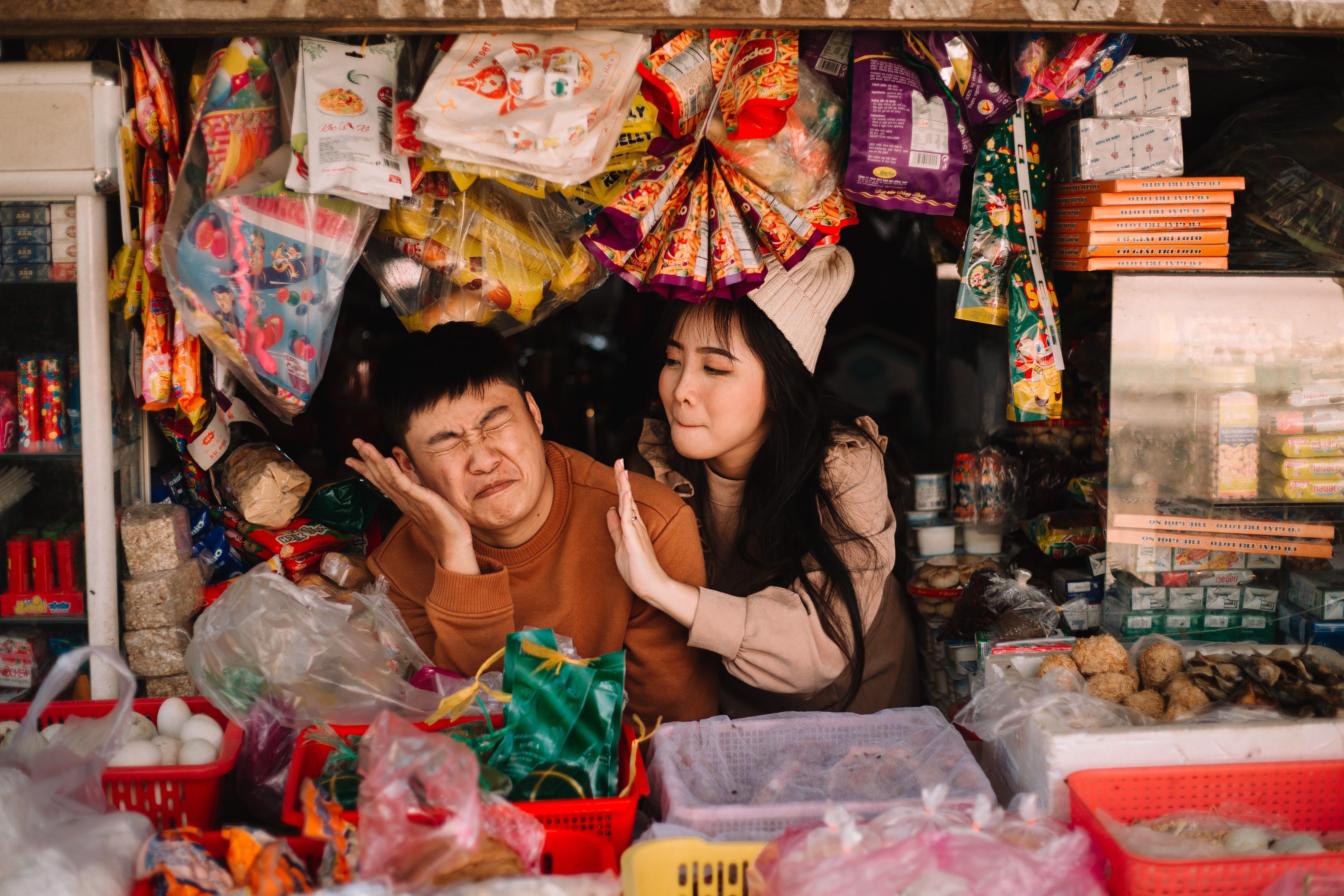 group of vendors laughing together while arranging goods in a market stall