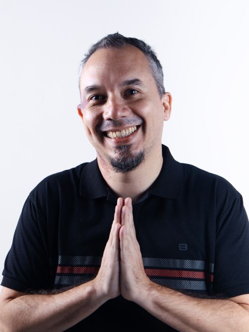 Free Happy adult man with hands in prayer pose against a white backdrop. Stock Photo