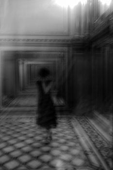 A blurred silhouette of a person walking through a vintage hallway creates a mysterious ambiance.