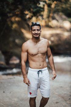 Athletic young man standing confidently in nature, showing fitness and vitality.