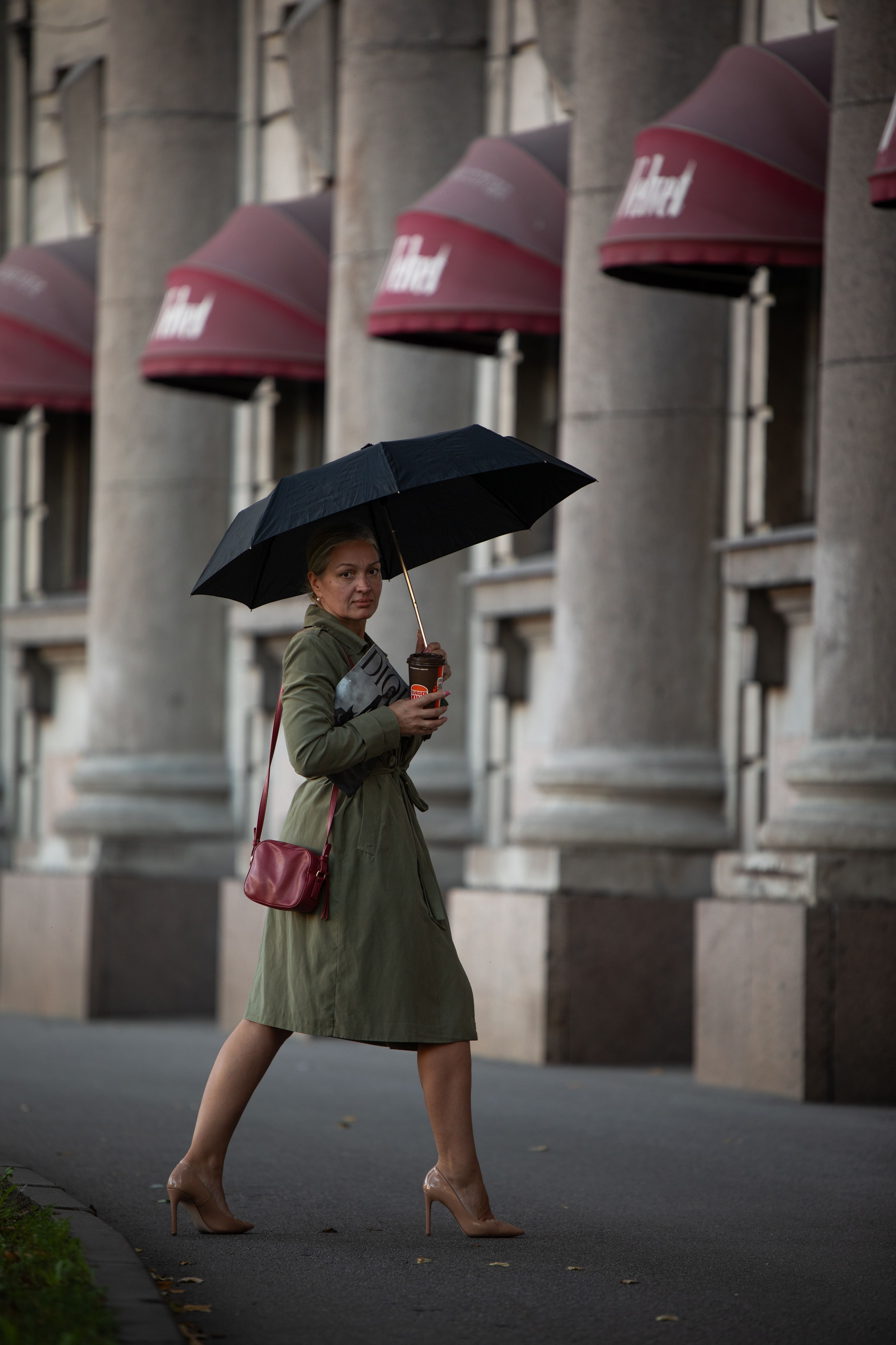 Woman walking with umbrella in urban setting · Free Stock Photo
