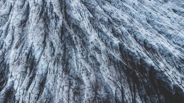 A detailed aerial view of icy glacier textures highlighting natural patterns and rugged beauty.