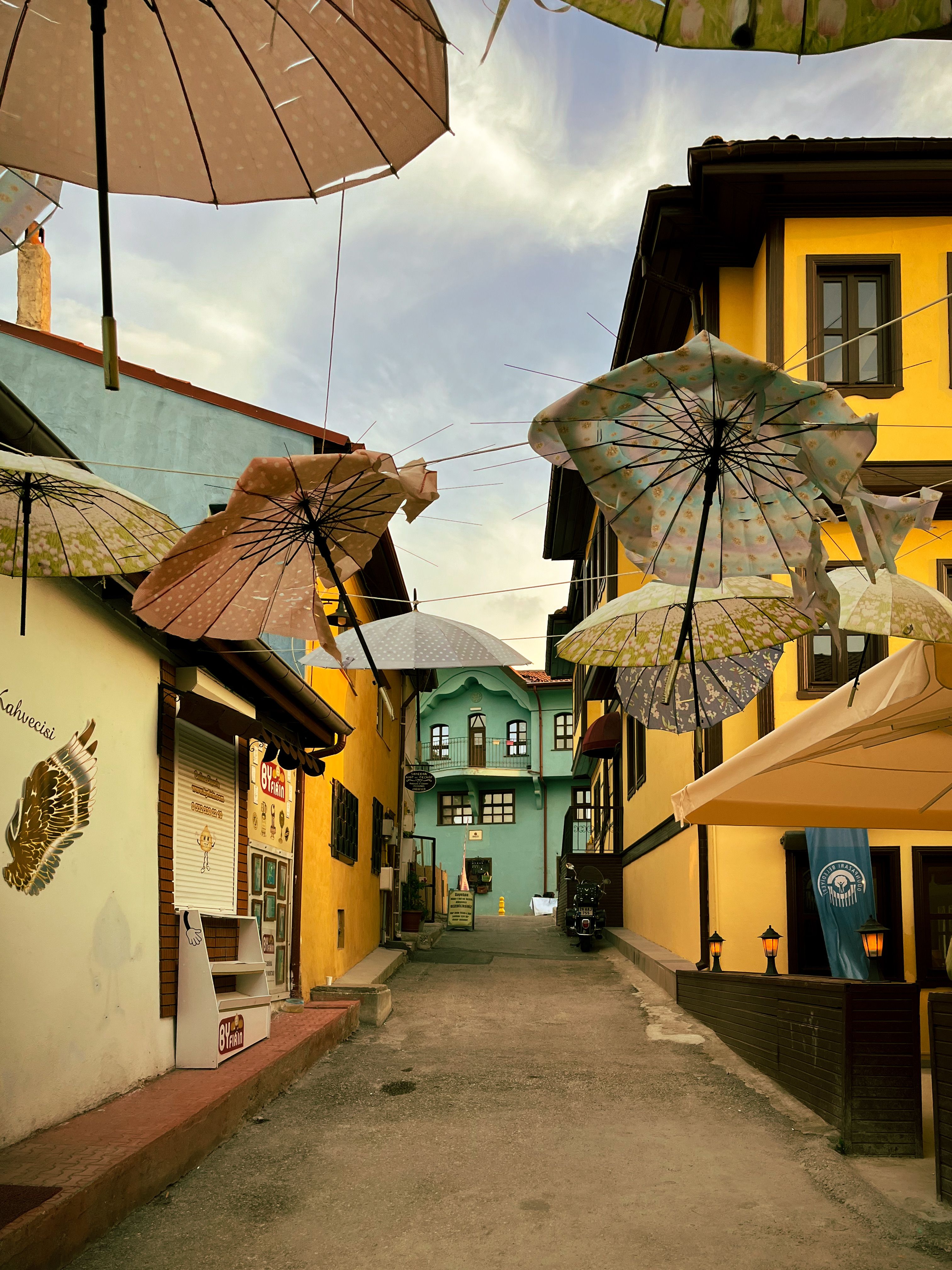 Colorful umbrellas and traditional houses create a lively street view in Odunpazarı, Eskişehir.