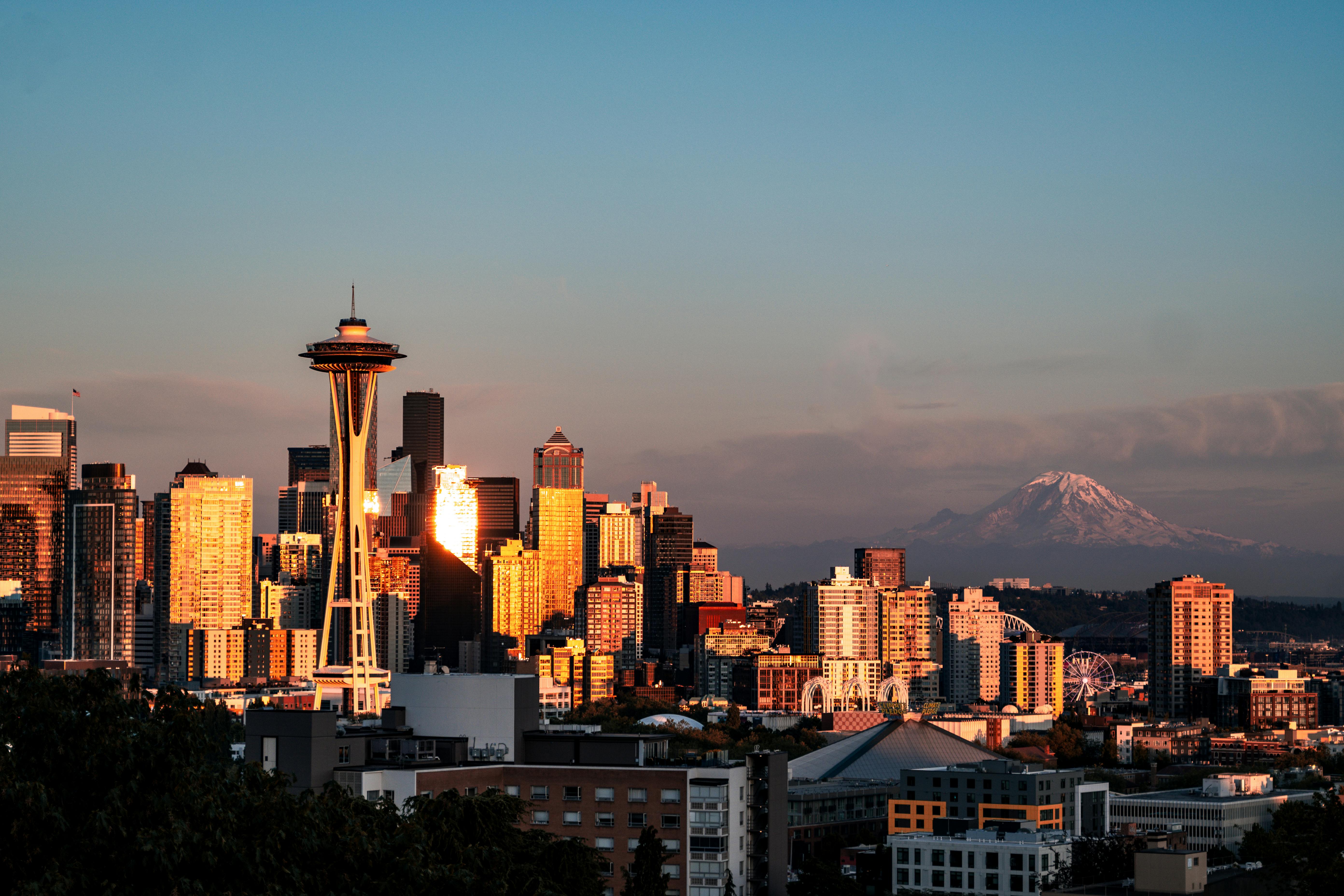 Stunning sunset view of the Seattle skyline with the Space Needle and Mount Rainier in the background.