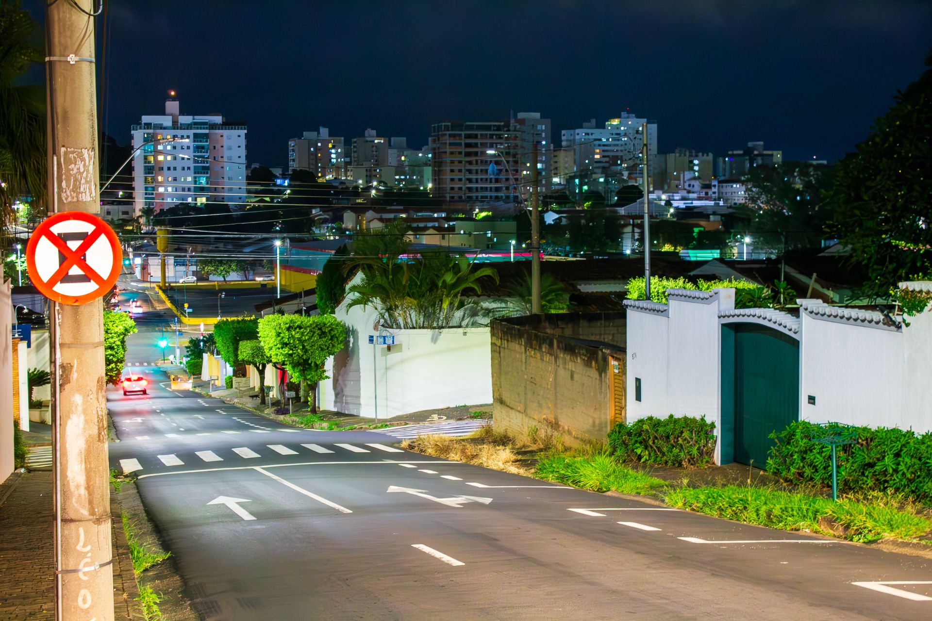 Vibrant night street scene in Uberlândia, Brazil showcasing illuminated buildings and road signs.
