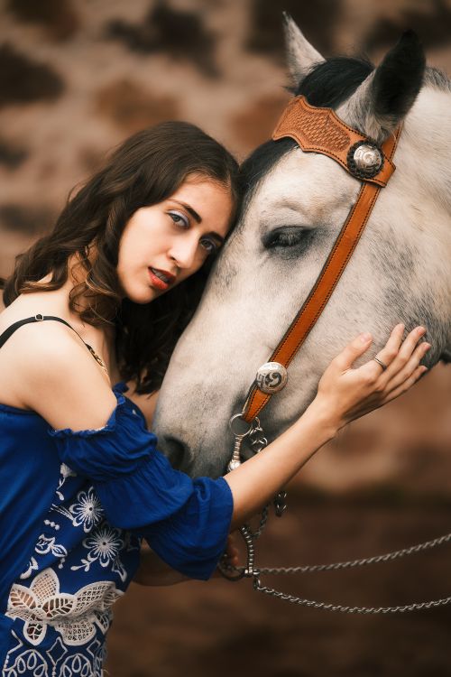 Free A woman in traditional Mexican attire lovingly embraces a horse, reflecting cultural heritage. Stock Photo