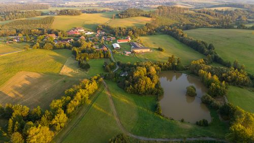 Free Stunning aerial view of Zbraslavice countryside with fields, forest, and pond at sunset. Stock Photo