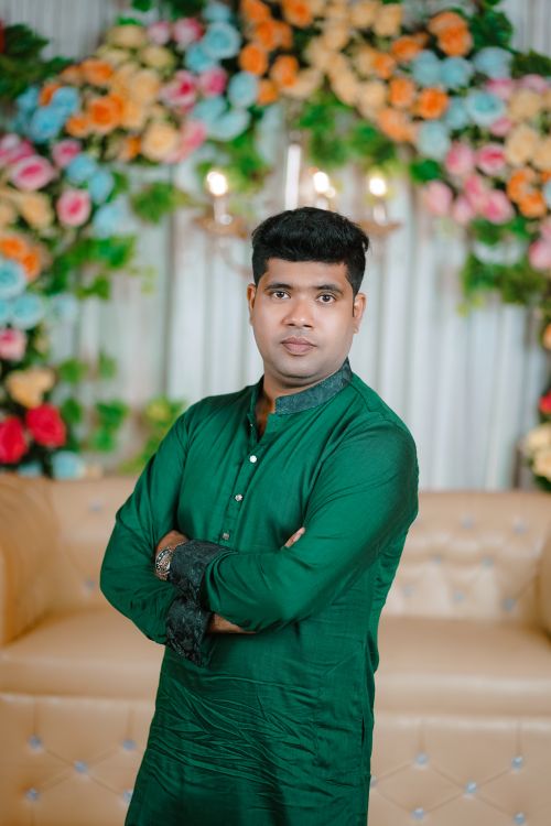 Free A South Asian man poses in traditional attire, with a vibrant floral wedding backdrop. Stock Photo