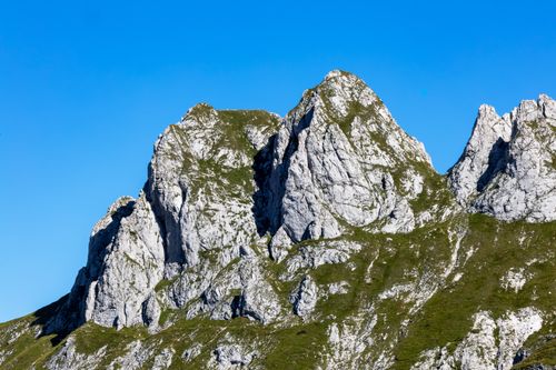 Free Stunning alpine mountain peaks towering under a clear blue sky, showcasing rugged beauty. Stock Photo