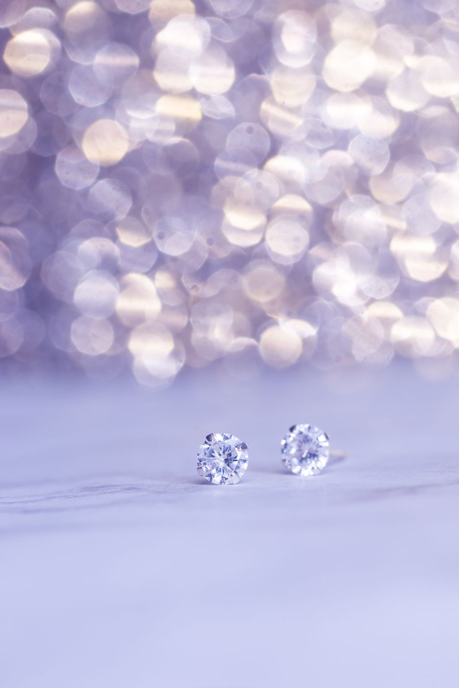 Sparkling diamond earrings with bokeh background