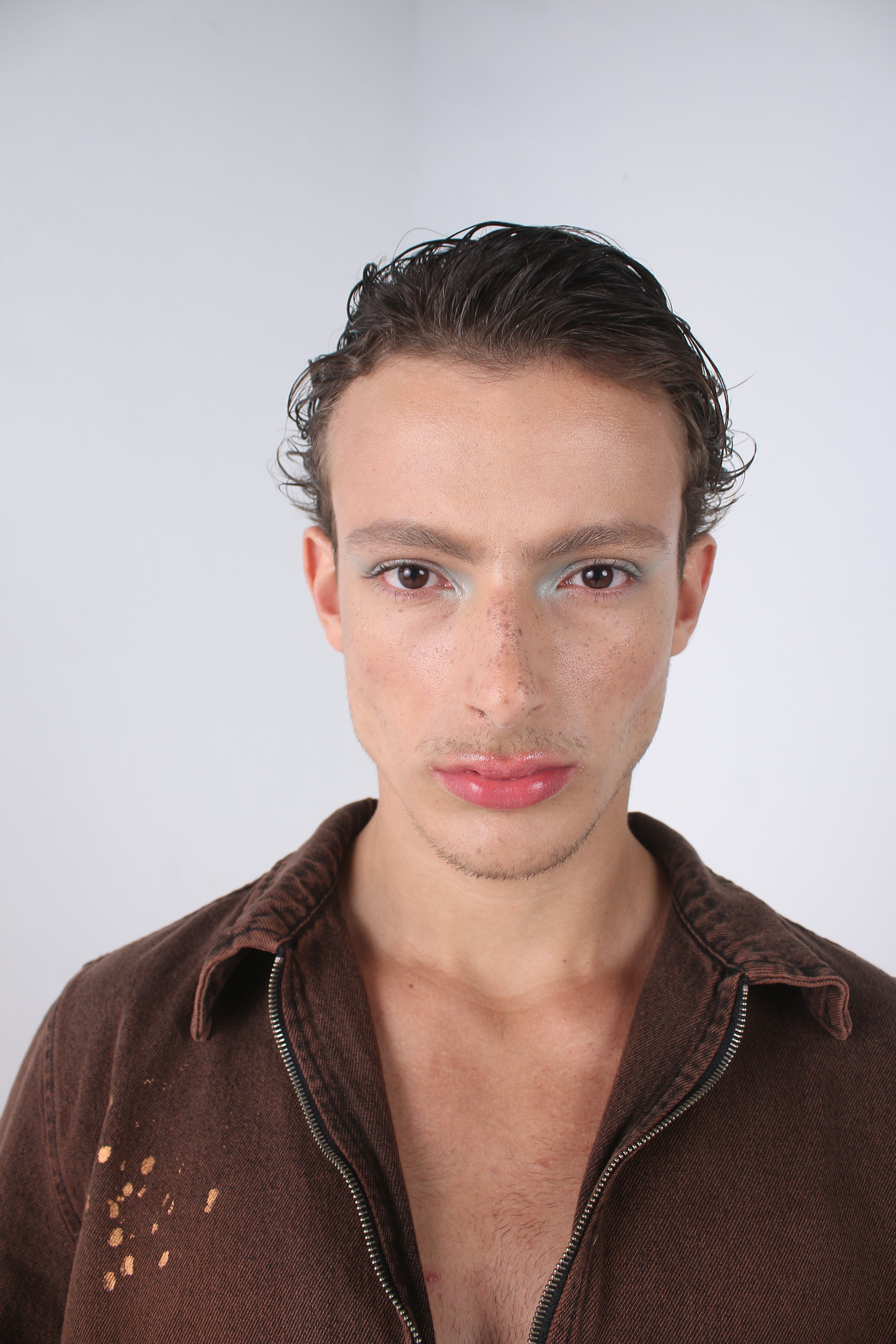 Close-up portrait of a model showcasing minimalist fashion style in a studio setting.