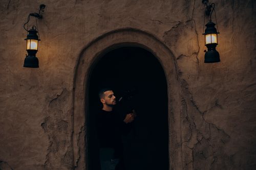 Free A photographer in old Dubai under warm lighting, highlighting the heritage architecture of Shindagha. Stock Photo