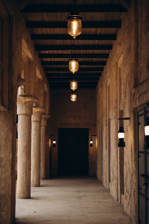 Free Explore the rustic charm of a traditional corridor in Shindagha, Dubai, featuring warm atmospheric lighting. Stock Photo