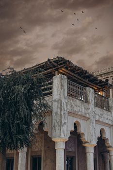 Elegant historical building in Shindagha, Dubai, showcasing traditional Middle Eastern architecture under a dramatic sky.