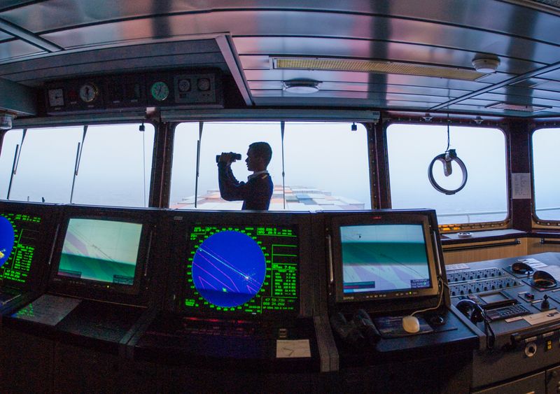 Officer navigating on a cargo ship bridge