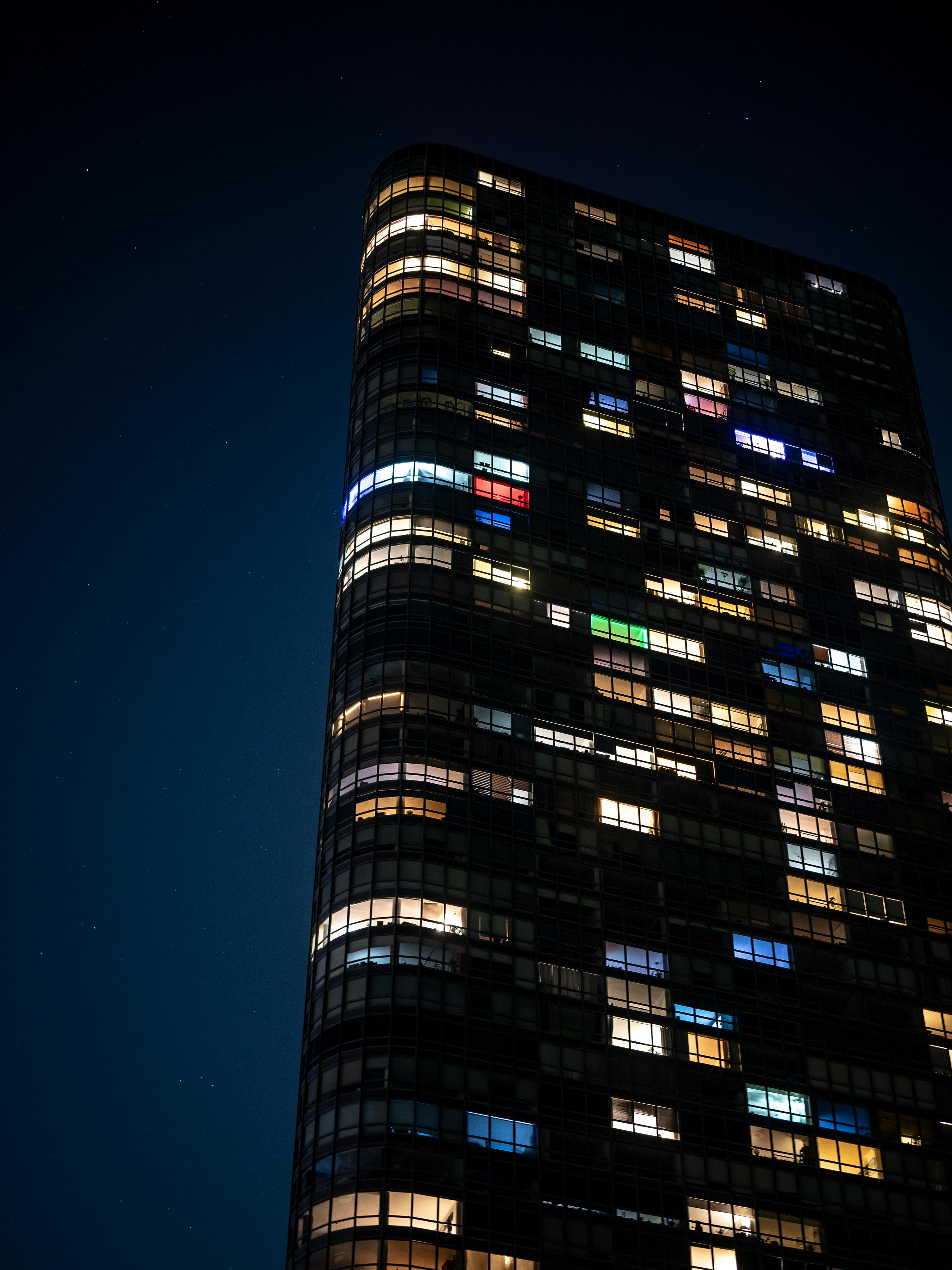 High-rise building with colorful illuminated windows in Chicago, captured against a night sky.
