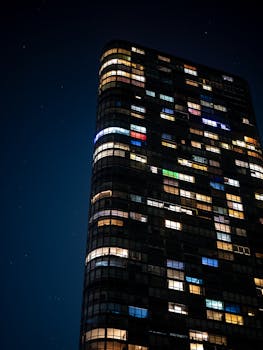 High-rise building with colorful illuminated windows in Chicago, captured against a night sky.