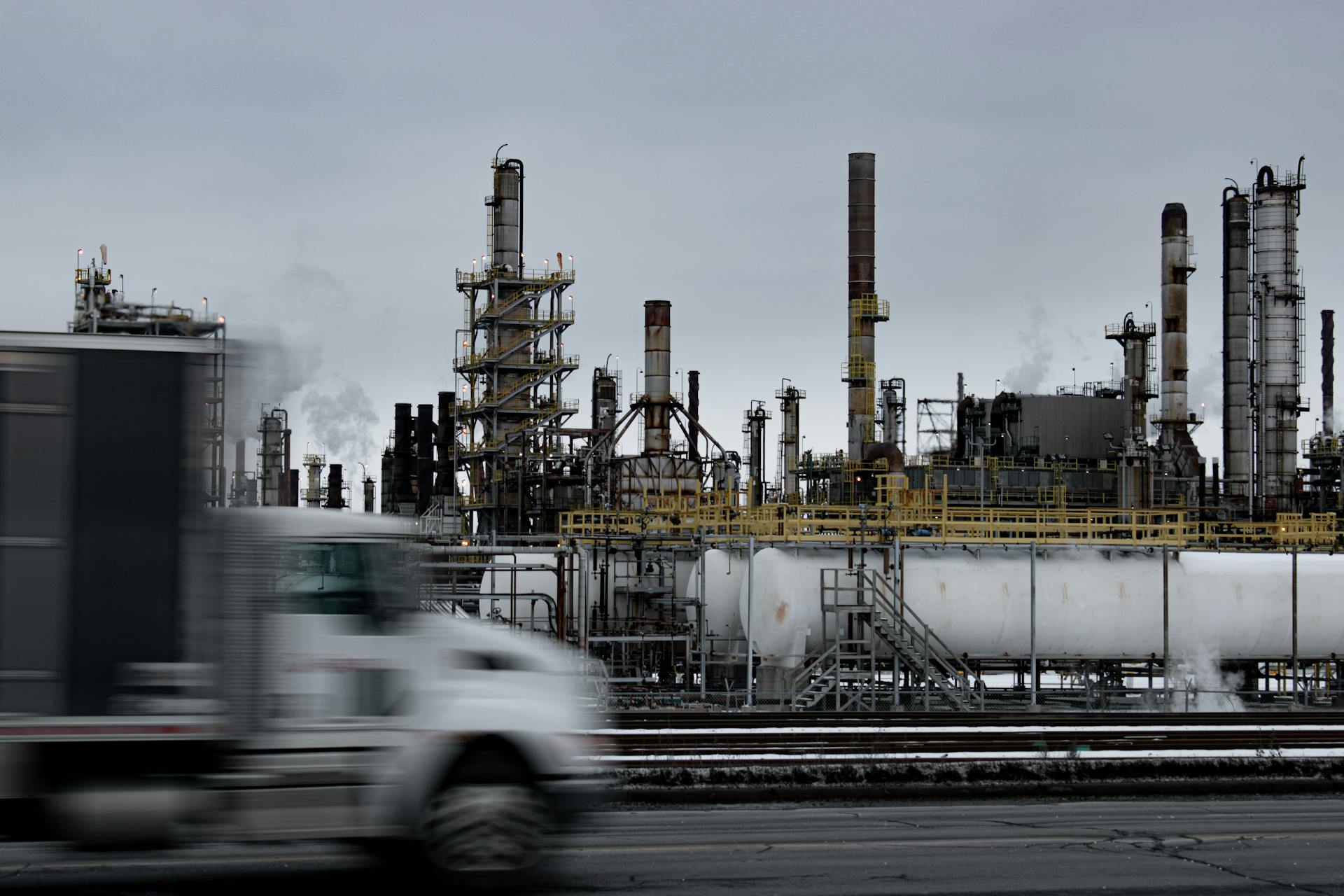 Industrial Factory with Passing Truck at Dusk