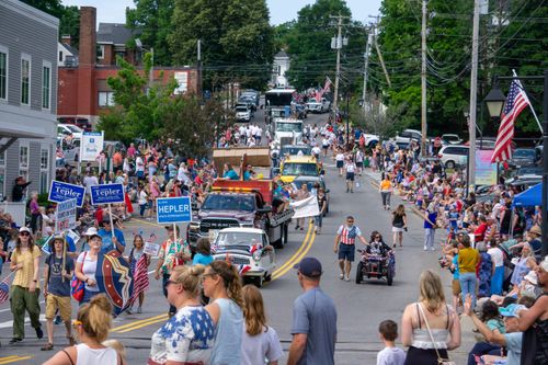 Free Crowds gather on a sunny day for a festive parade with colorful floats and banners. Stock Photo