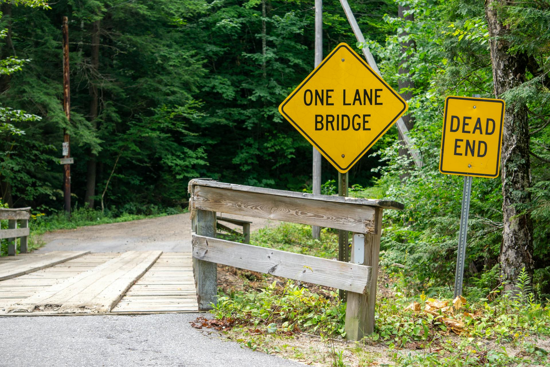 Rustic One Lane Bridge with Warning Signs in Forest