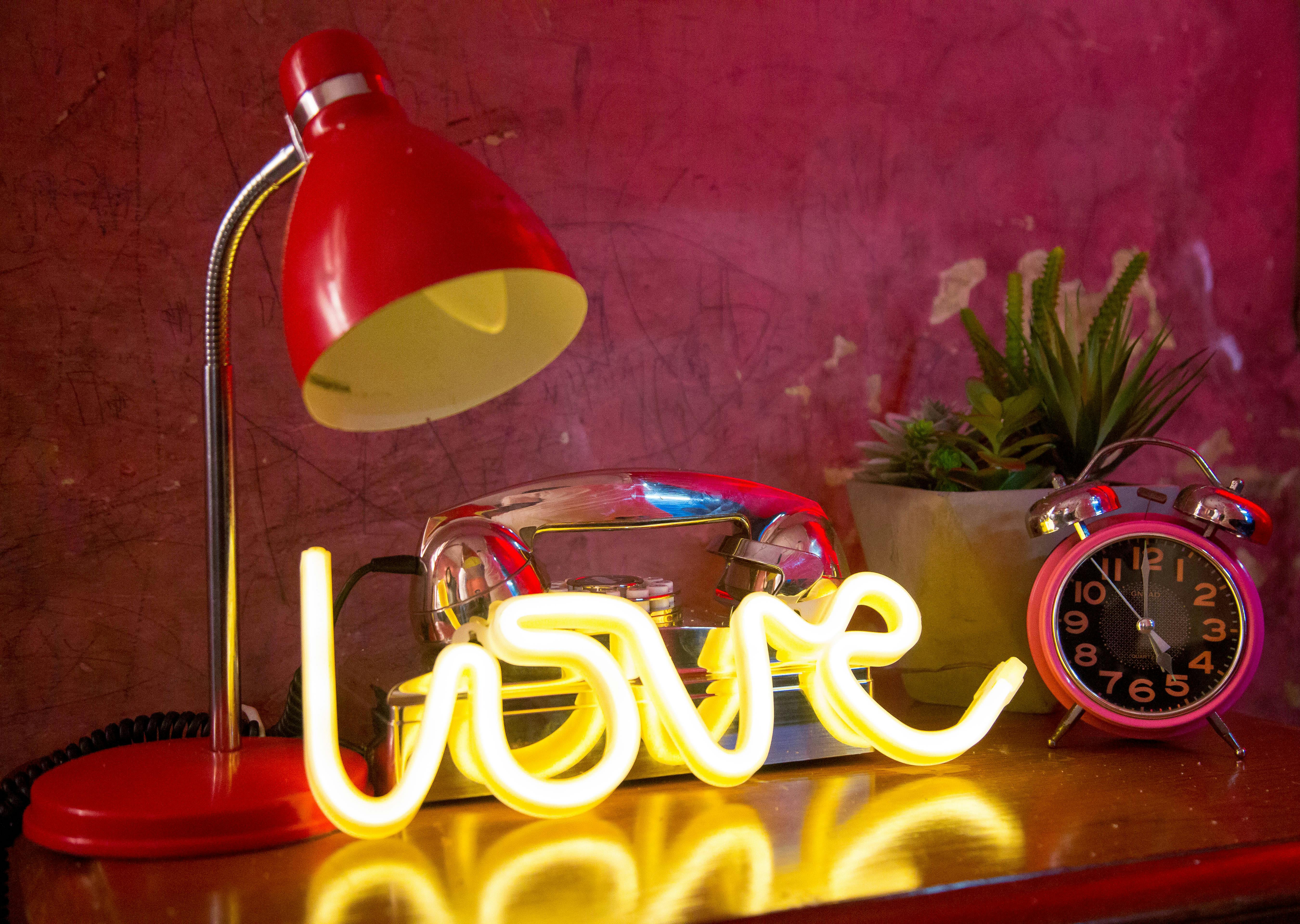 Bright neon love sign with retro decor, perfect for romantic vibes.