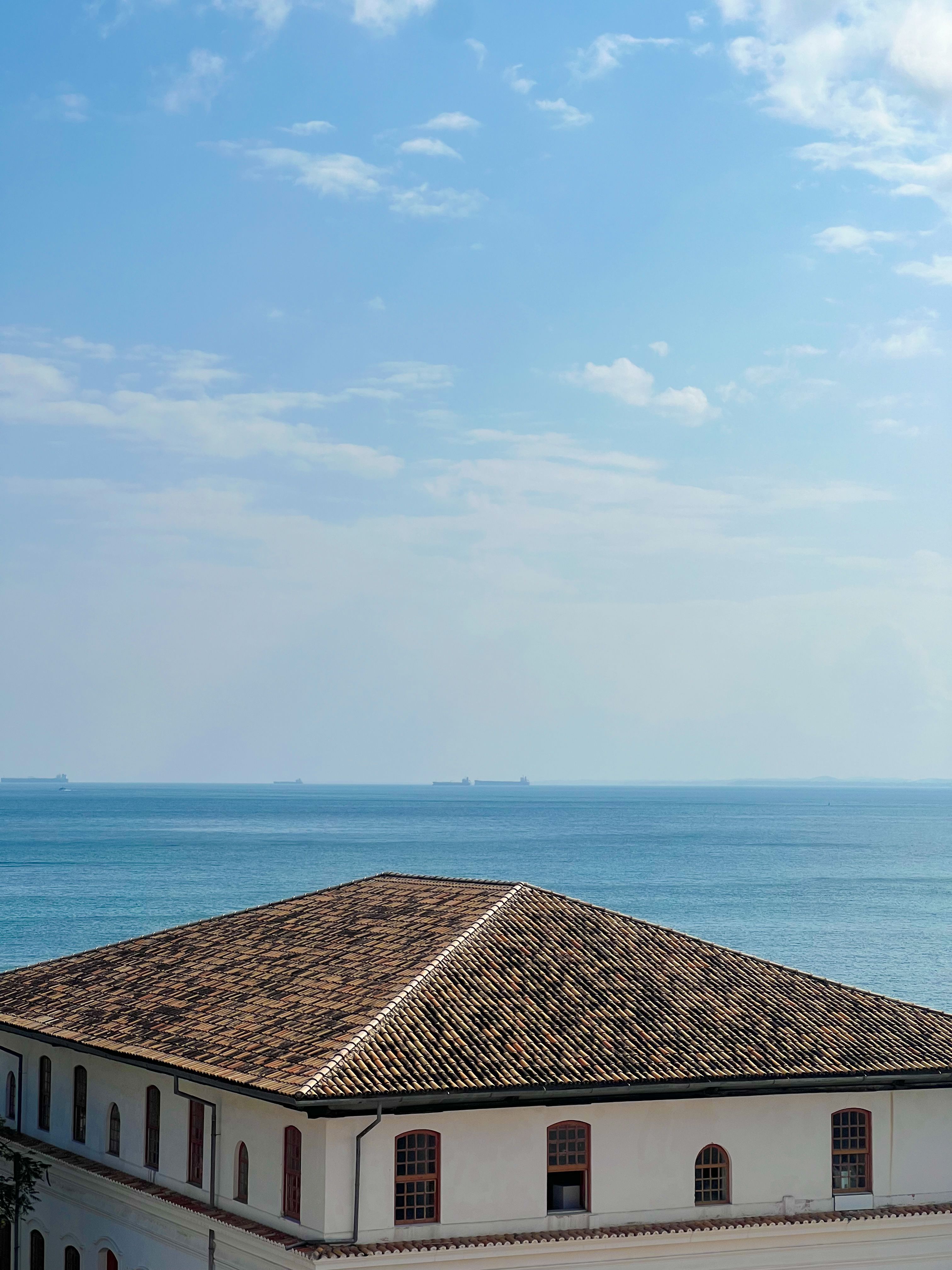Coastal Rooftop with Ocean View Under Blue Sky · Free Stock Photo