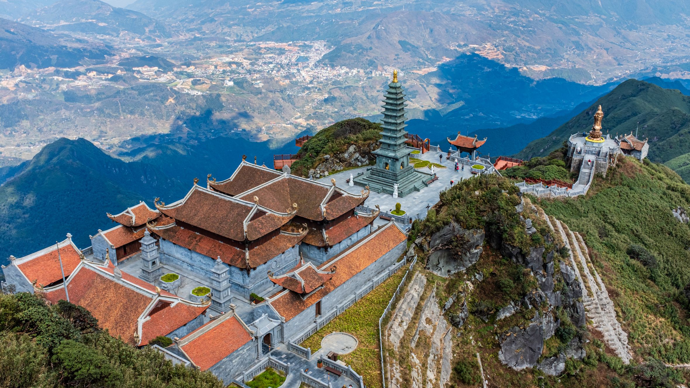 Scenic aerial view of Fansipan Pagoda Complex surrounded by mountains in Vietnam. Captures architectural elegance.