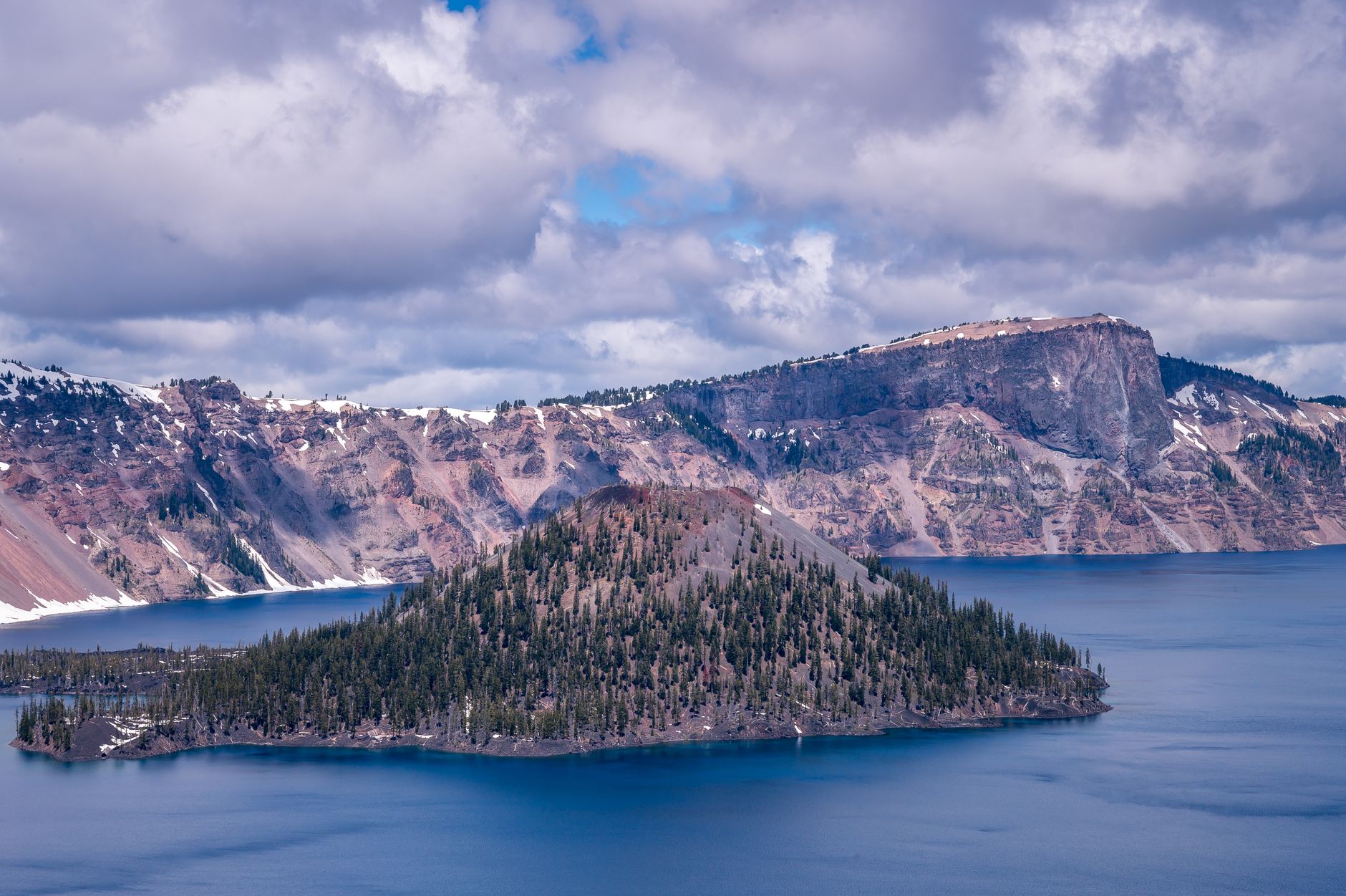 Crater Lake's blue water below rocky caldera cliffs, Oregon