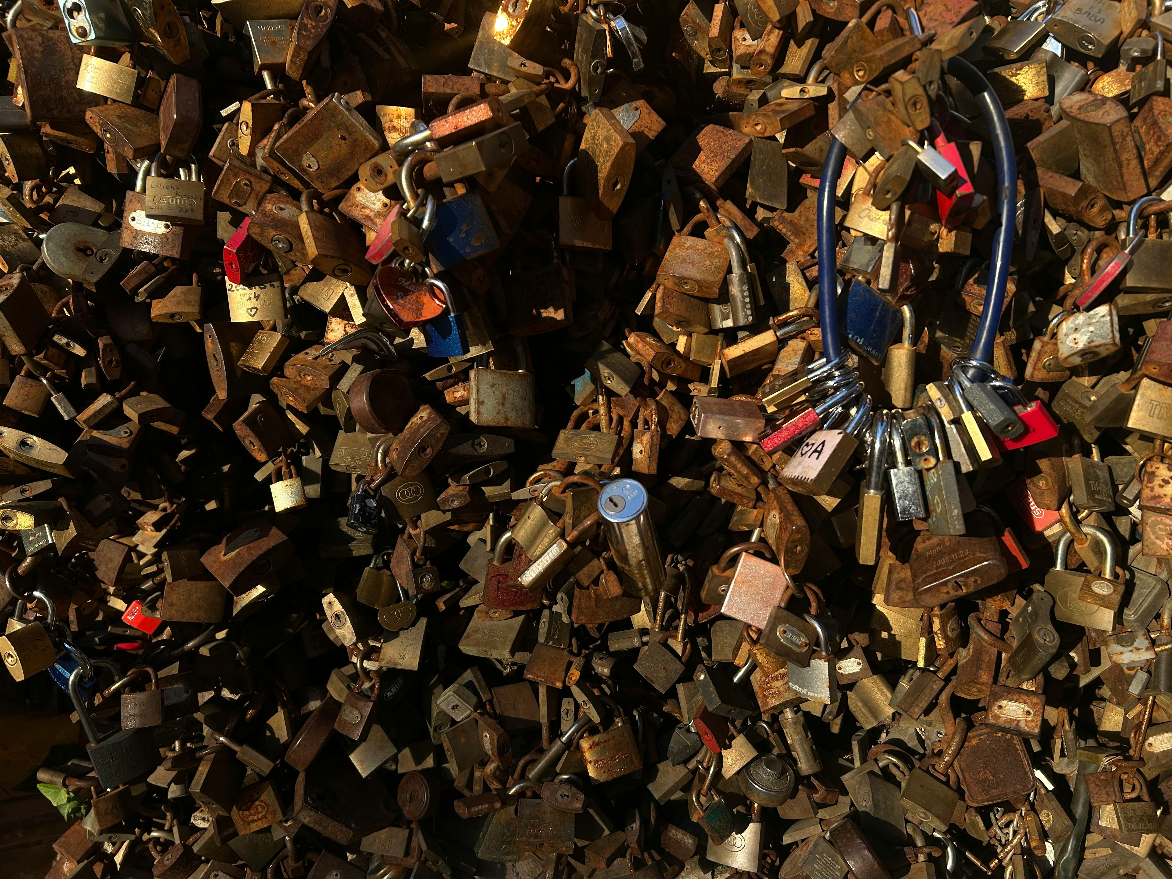 A collection of rusty padlocks attached to a bridge fence in Pecs, Hungary, symbolizing everlasting love.
