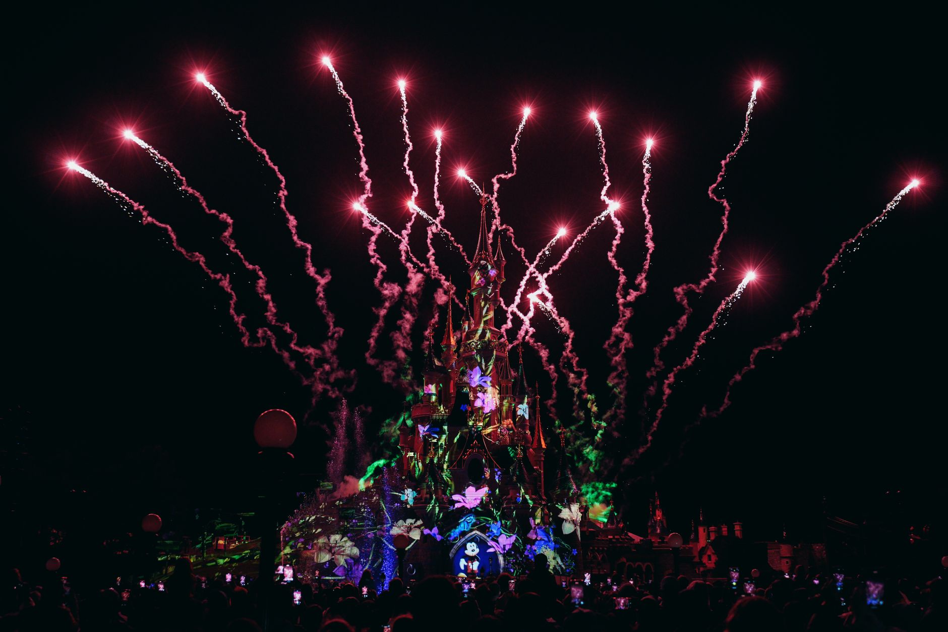 Dazzling fireworks light up the night sky at Disneyland Paris, showcasing the enchanting castle.
