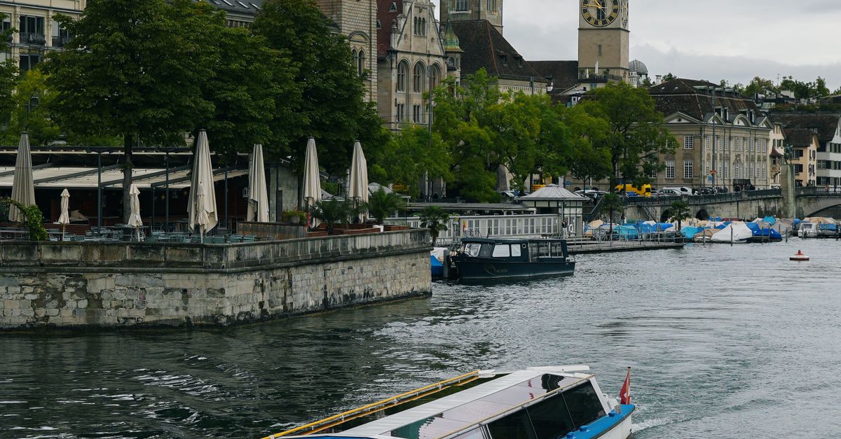 A picturesque boat journey on the River Limmat with Zürich's historic architecture in the background.