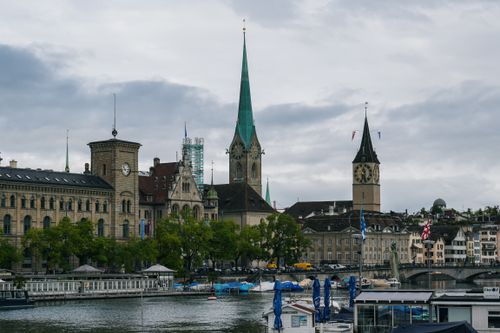 Scenic view of Zürich with church towers and river on a cloudy day.