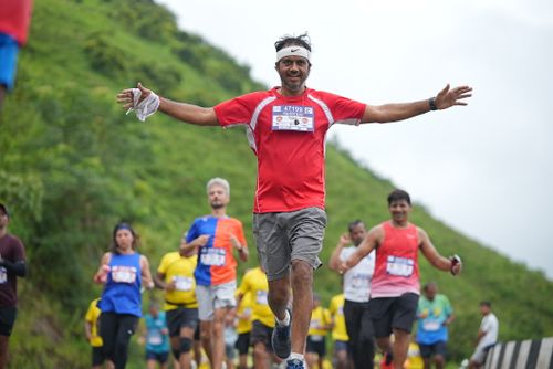 Free Dynamic scene of a marathon runner embracing victory with others in a scenic outdoor race. Stock Photo
