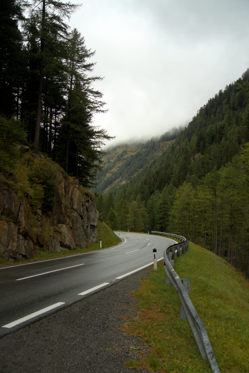 Free Serene mountain road winding through lush forests in Soelden, Tyrol on an overcast day. Stock Photo