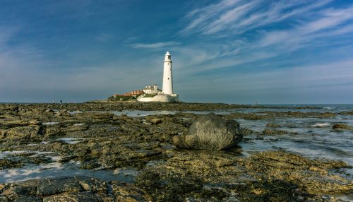 Free Stunning view of St Mary's Lighthouse on a rocky coast under a blue sky. Stock Photo