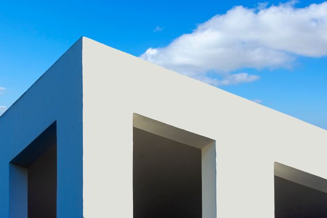 Minimal white building facade against a blue sky — photo by Jan van der Wolf on Pexels