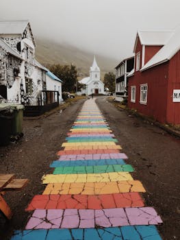 一条充满活力的彩虹小径将目光引向冰岛村庄里一座风景如画的教堂